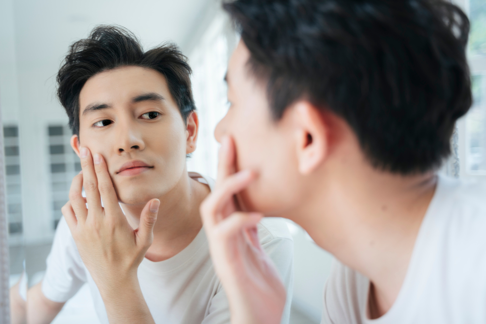 Man looking in the mirror after getting PRP for Under Eyes